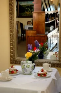 Patisserie Boissiere table with desserts and fresh flowers in front of a mirror